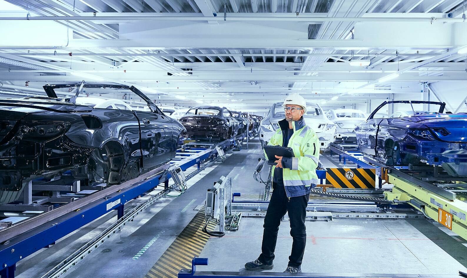 Leadec employee monitoring the automated conveyor technology using a tablet.