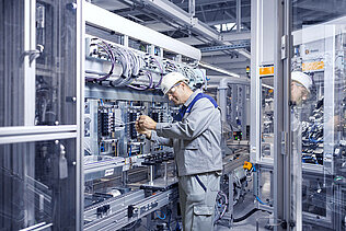 A Leadec employee checking the electronics of an automatic station.